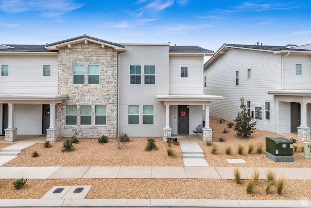 view of front of house featuring stone siding and stucco siding