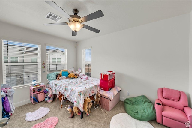 carpeted bedroom featuring baseboards, visible vents, and a ceiling fan