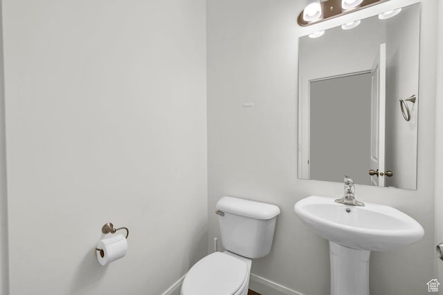 bathroom featuring baseboards and toilet