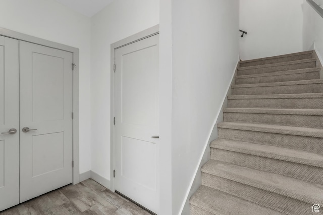 stairway featuring baseboards and wood finished floors