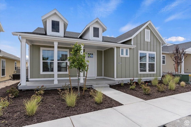 view of front facade featuring central AC unit, board and batten siding, and a porch