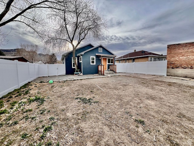 back of house with stucco siding and a fenced backyard
