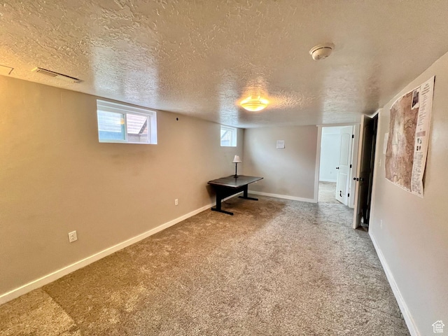 basement featuring baseboards, visible vents, and carpet