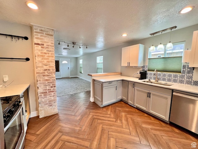 kitchen with open floor plan, light countertops, a sink, and stainless steel appliances