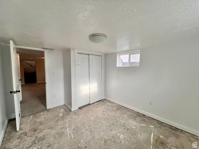 unfurnished bedroom with baseboards, a textured ceiling, and a closet
