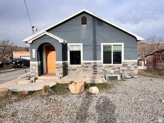 view of front facade featuring stone siding and stucco siding