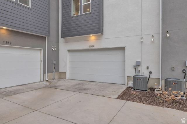 garage featuring driveway and central AC unit