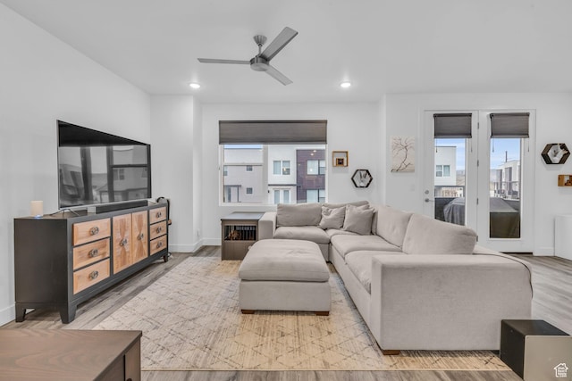 living area with a ceiling fan, recessed lighting, baseboards, and light wood-type flooring