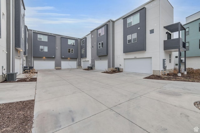 exterior space featuring cooling unit, stucco siding, driveway, and a garage