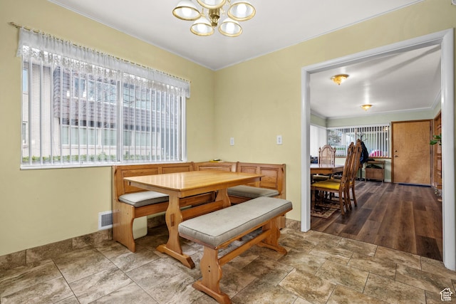 dining space with crown molding, visible vents, a notable chandelier, and plenty of natural light