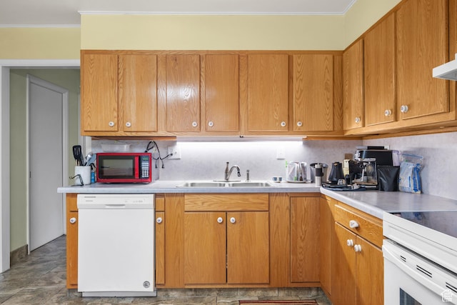 kitchen featuring light countertops, a sink, ornamental molding, and white appliances