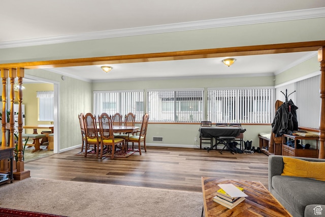 living room with wood finished floors, ornamental molding, baseboards, and visible vents