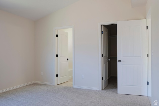 918 N Gypsum Dr, Tooele, UT 84074 - unfurnished bedroom featuring lofted ceiling, a spacious closet, connected bathroom, light carpet, and a closet