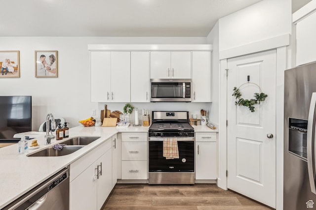 917 W 1000 N Unit 6, Tremonton, UT 84337 - kitchen with wood finished floors, a sink, white cabinetry, light countertops, and appliances with stainless steel finishes
