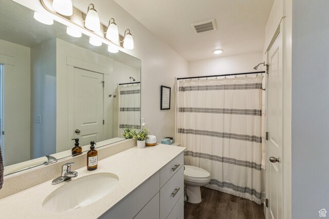 917 W 1000 N Unit 6, Tremonton, UT 84337 - full bath with wood finished floors, visible vents, toilet, vanity, and a shower with shower curtain