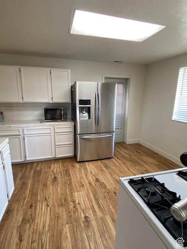 369 E 400 S, Springville, UT 84663 - kitchen featuring white range with gas stovetop, tile counters, stainless steel fridge, white cabinetry, and black microwave