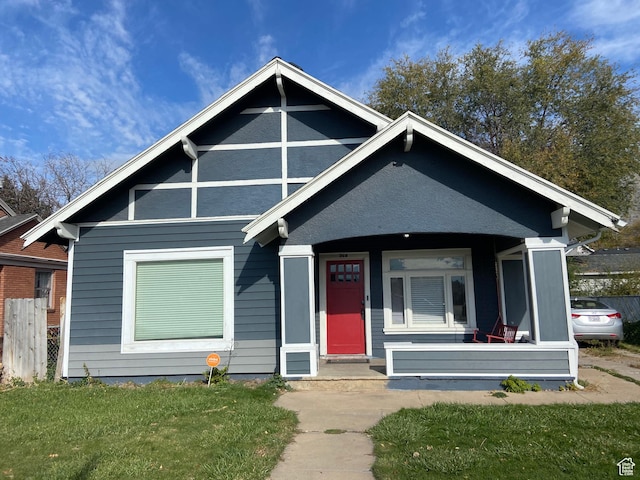 bungalow with covered porch and a front yard