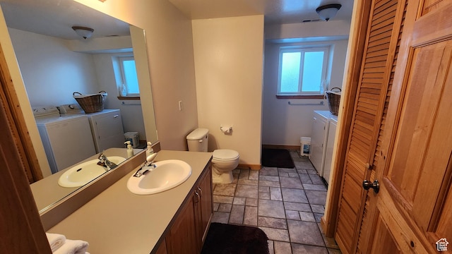 2568 Foxridge Dr, Garden City, UT 84028 - bathroom featuring washer and clothes dryer, stone tile flooring, toilet, and plenty of natural light