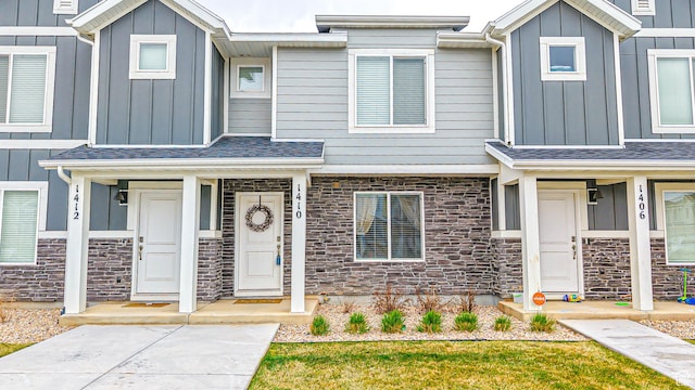 multi unit property with stone siding, board and batten siding, and roof with shingles