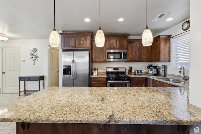 6212 W 100 S, Hurricane, UT 84737 - kitchen with light stone counters, a sink, pendant lighting, stainless steel appliances, and visible vents