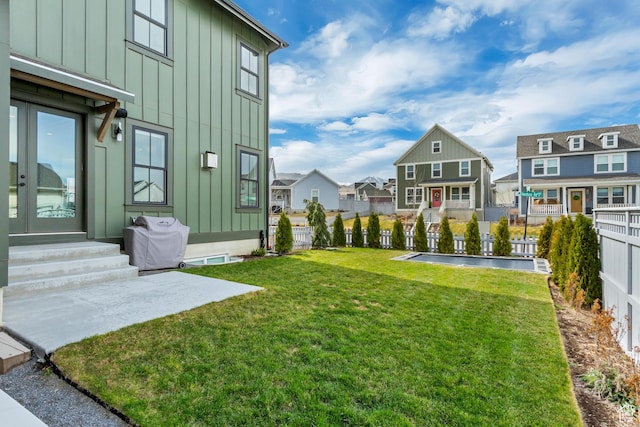 view of yard with a fenced backyard, entry steps, and a residential view