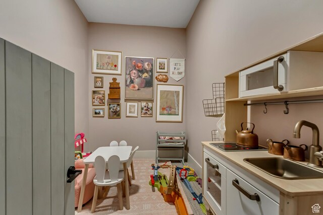 kitchen with light countertops, a sink, and baseboards