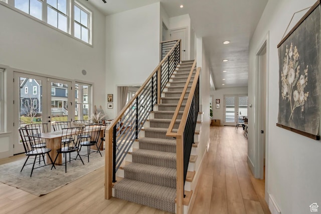 entryway featuring stairs, a wealth of natural light, wood finished floors, and french doors