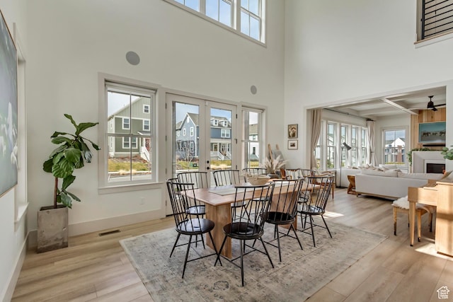 dining space featuring baseboards, visible vents, light wood-style flooring, and ceiling fan