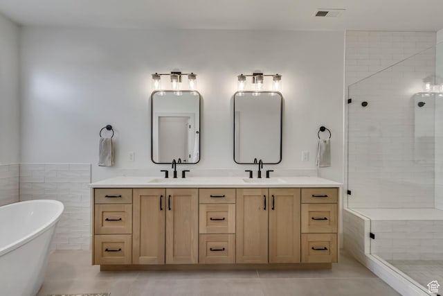bathroom with a sink, a shower stall, a soaking tub, visible vents, and double vanity