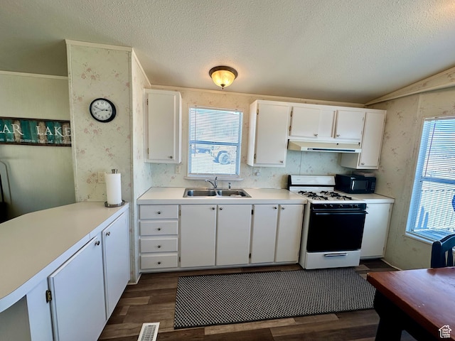 3068 S Monarch Cir Unit 343, Garden City, UT 84028 - kitchen with white range with gas stovetop, under cabinet range hood, dark wood-style floors, white cabinetry, and black microwave