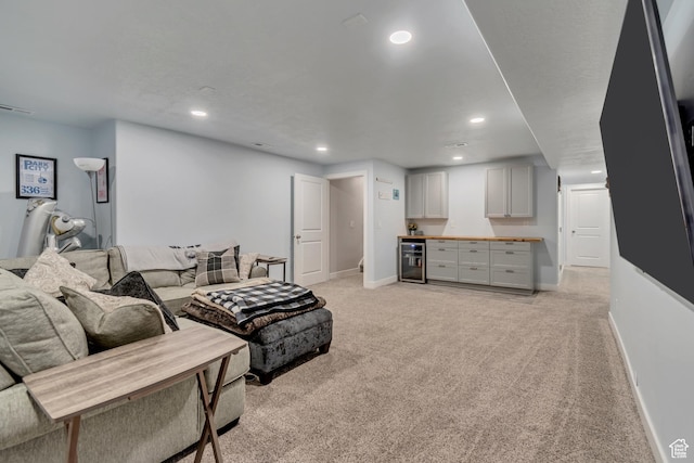living room with baseboards, wine cooler, recessed lighting, and light colored carpet