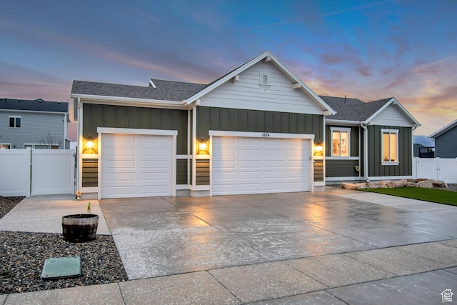 ranch-style home featuring board and batten siding, driveway, a garage, and fence