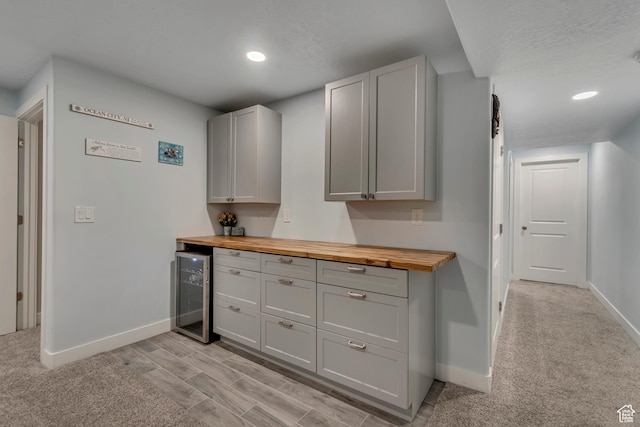 kitchen with wood counters, baseboards, and wine cooler