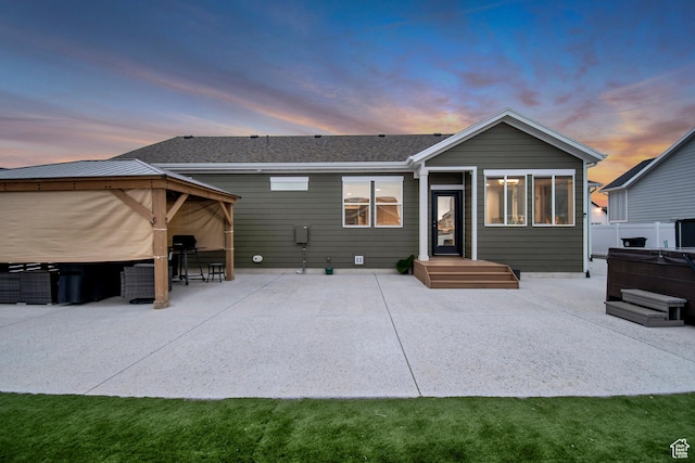 back of house featuring fence, a patio area, and a hot tub