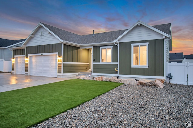 view of front of home with fence, an attached garage, concrete driveway, a front lawn, and board and batten siding