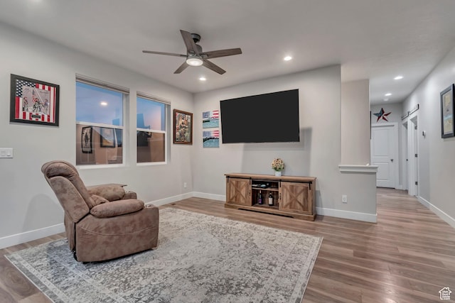 living area with baseboards, wood finished floors, recessed lighting, and a ceiling fan