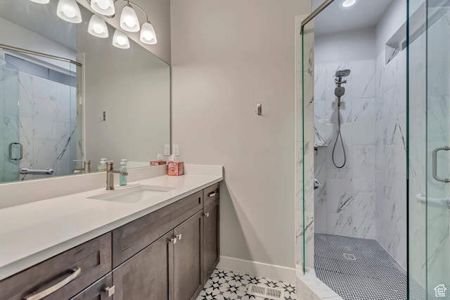 full bath featuring baseboards, a marble finish shower, and vanity