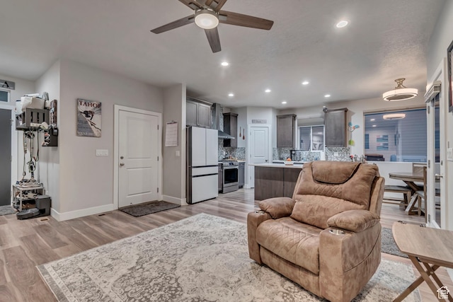 living room featuring recessed lighting, baseboards, light wood-style floors, and ceiling fan