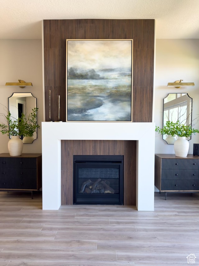 4436 W 1050 S Unit 104, West Point, UT 84015 - room details with a glass covered fireplace, a textured ceiling, and wood finished floors