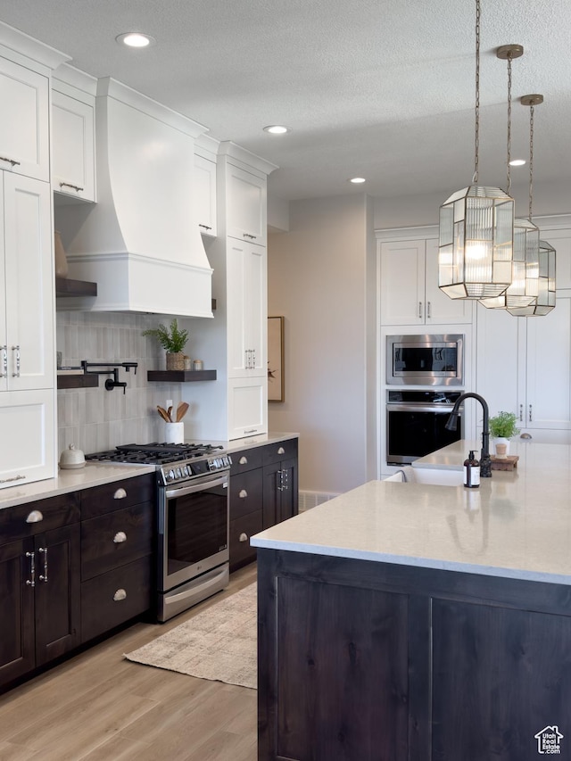 4436 W 1050 S Unit 104, West Point, UT 84015 - kitchen with white cabinetry, tasteful backsplash, custom range hood, and stainless steel appliances