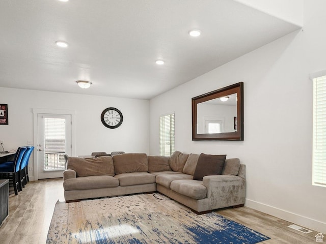 7756 W Bellfield Rd, Magna, UT 84044 - living room featuring baseboards, visible vents, light wood-style floors, and a healthy amount of sunlight