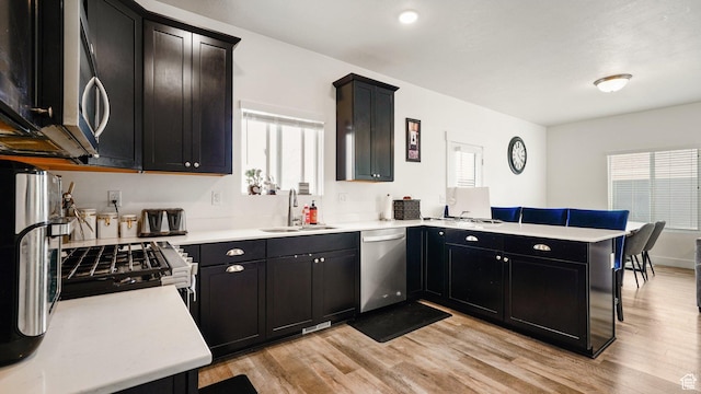 7756 W Bellfield Rd, Magna, UT 84044 - kitchen featuring light countertops, a peninsula, light wood finished floors, stainless steel appliances, and a sink