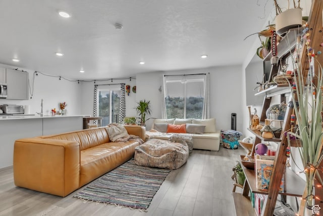 living area with light wood finished floors and recessed lighting
