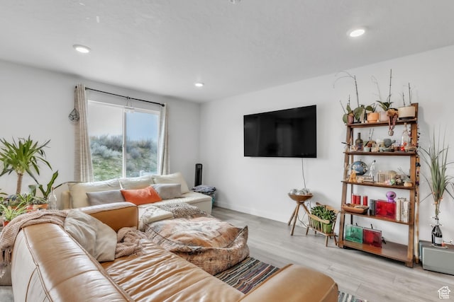 living room with light wood finished floors, baseboards, and recessed lighting
