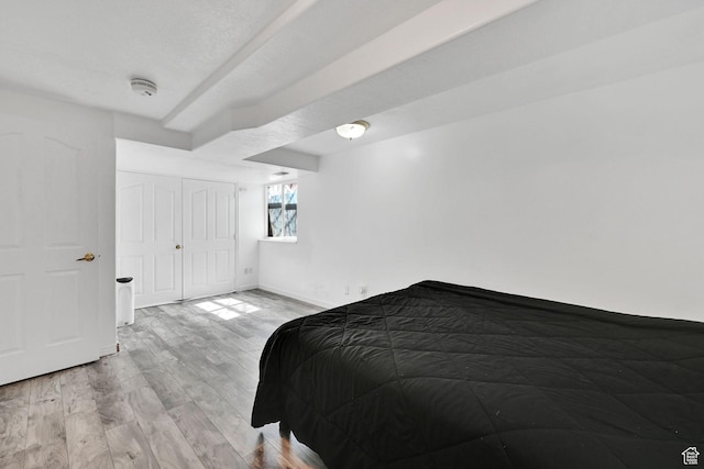 bedroom featuring light wood-style flooring, a closet, and baseboards