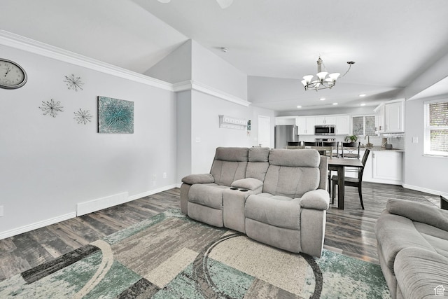 living room featuring dark wood-type flooring, a notable chandelier, baseboards, and vaulted ceiling