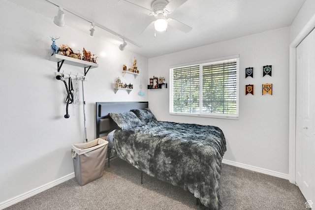bedroom with rail lighting, carpet flooring, and baseboards