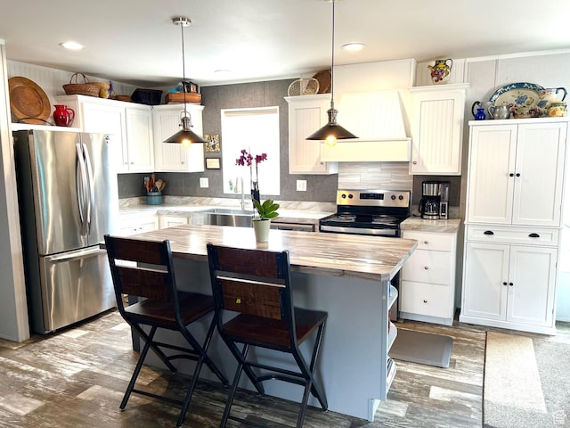 3203 S Nina Loop, Garden City, UT 84028 - kitchen with a kitchen bar, white cabinets, a sink, and stainless steel appliances
