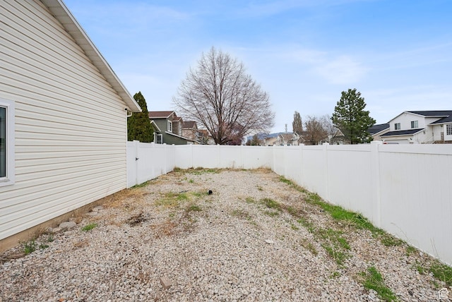 view of yard featuring a fenced backyard and a residential view