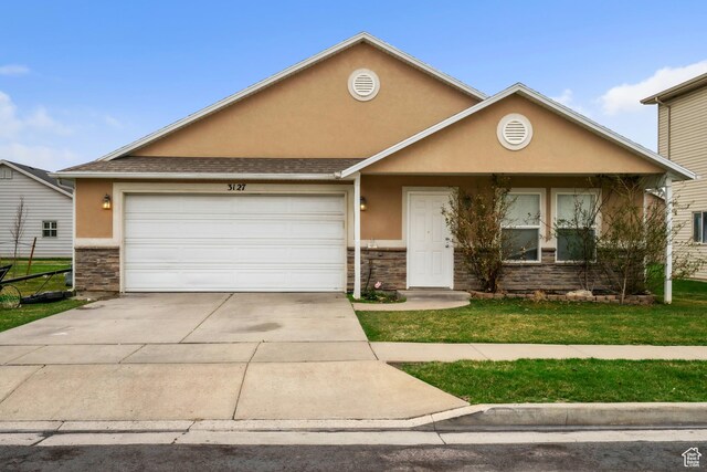 view of front of home with a front yard, stone siding, concrete driveway, stucco siding, and a garage